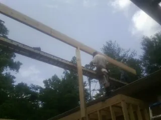 Carpenter setting a ridge beam over a new addition frame — Ice Dam Removal by Roofing Brothers in Cuddebackville