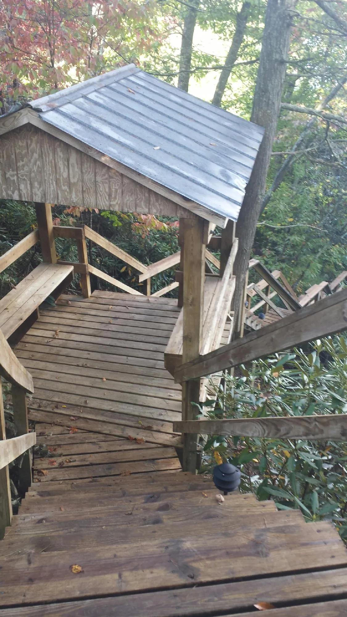 Metal roofed shelter over wooden steps on a wooded walkway — Skylight Repair & Installation work by our crew in Cuddebackville